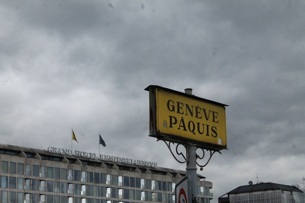 a yellow sign that says geneve paquis in front of a building
