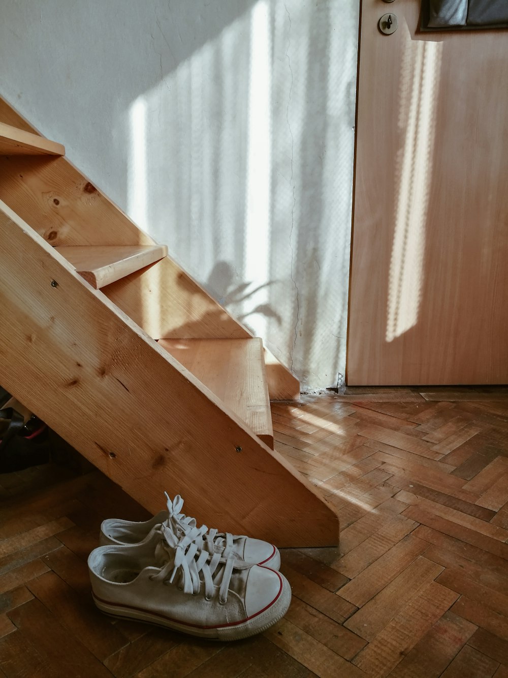 white sneakers on brown wooden staircase