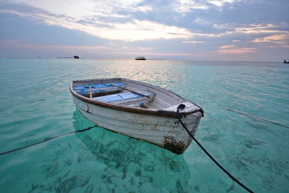 white and brown boat on blue sea under blue sky during daytime