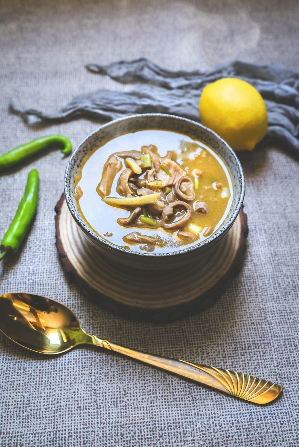 noodles in black ceramic bowl beside lemon fruit