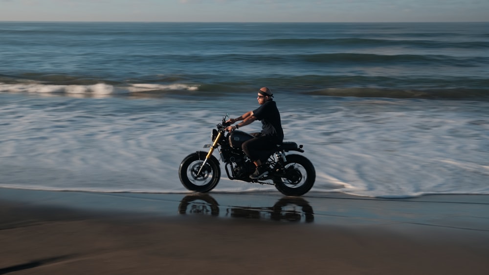 man in black jacket riding motorcycle on beach during daytime