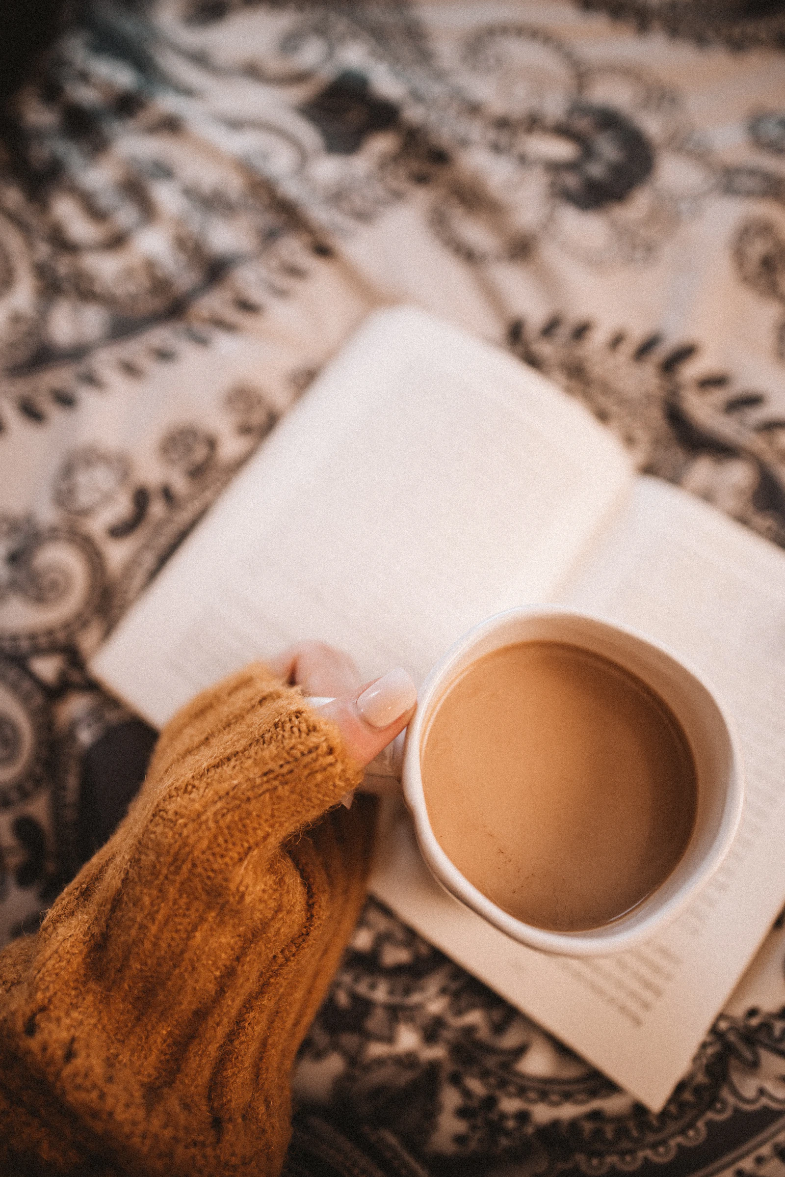 Moment calme avec une tasse de café et un carnet ouvert, ambiance cocooning