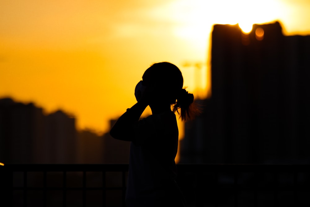 silhouette of woman standing during sunset