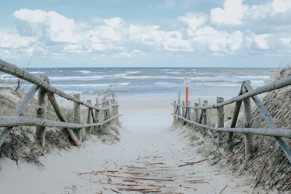 valla de madera marrón en la playa durante el día