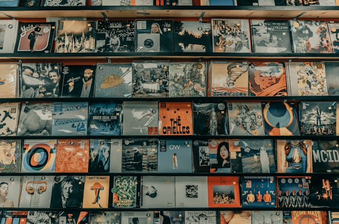 Graphic design of music albums displayed on a wall, example of music marketing