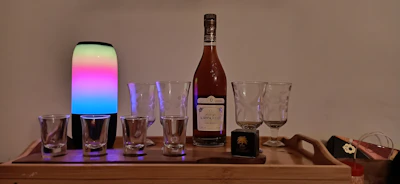 A set of whiskey glasses with custom etched initials on a polished wooden tray.