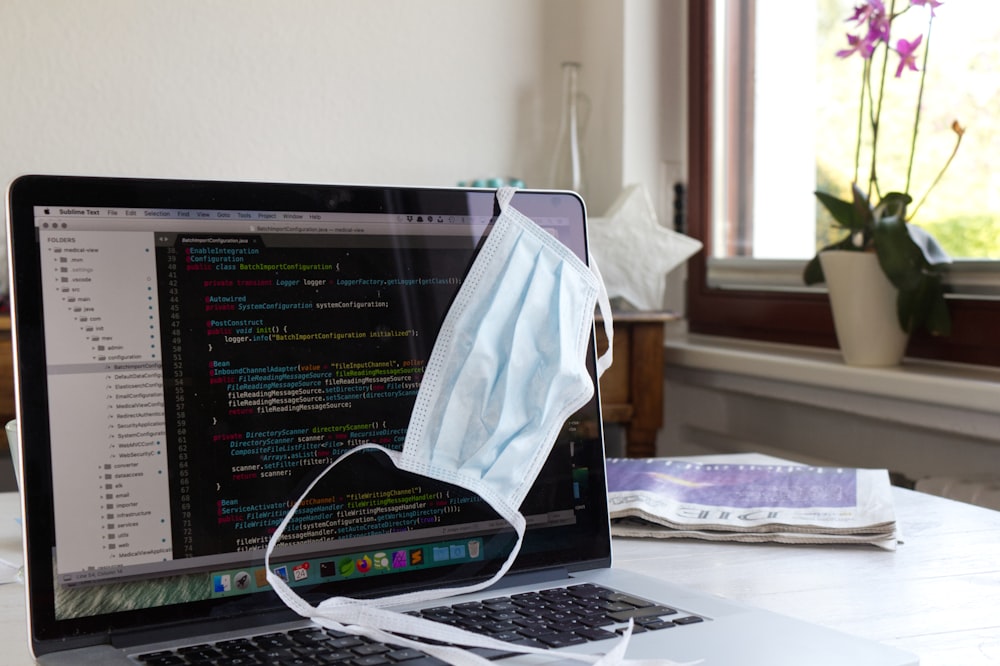 white laptop computer on white table