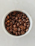 brown coffee beans in white ceramic bowl