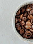 brown coffee beans on white ceramic bowl