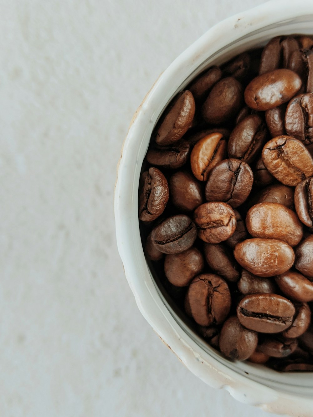 白いセラミックボウルに茶色のコーヒー豆