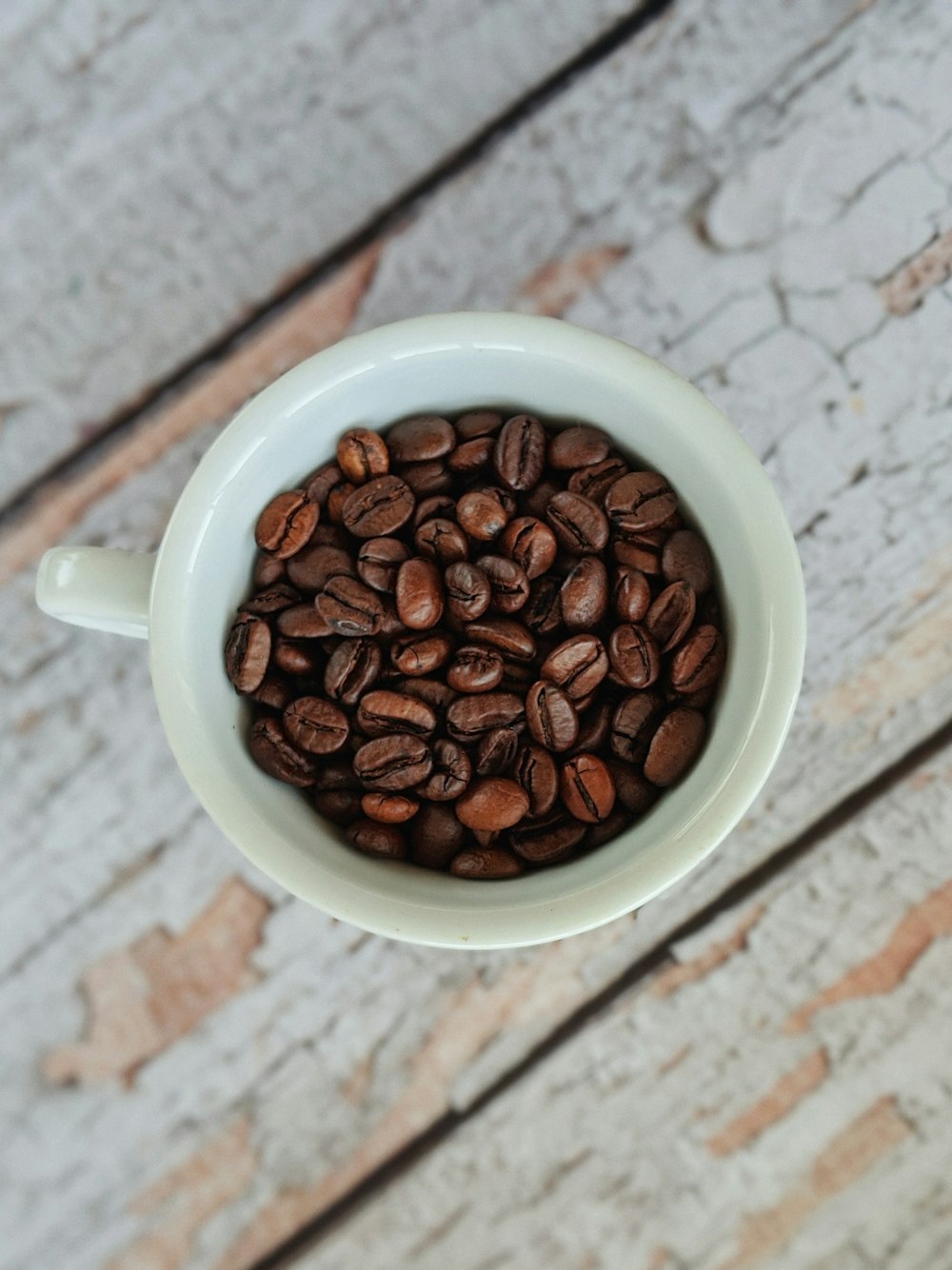 white ceramic mug with coffee beans