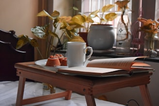 white ceramic mug on white book page on brown wooden table