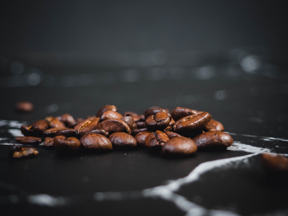 brown coffee beans on black surface