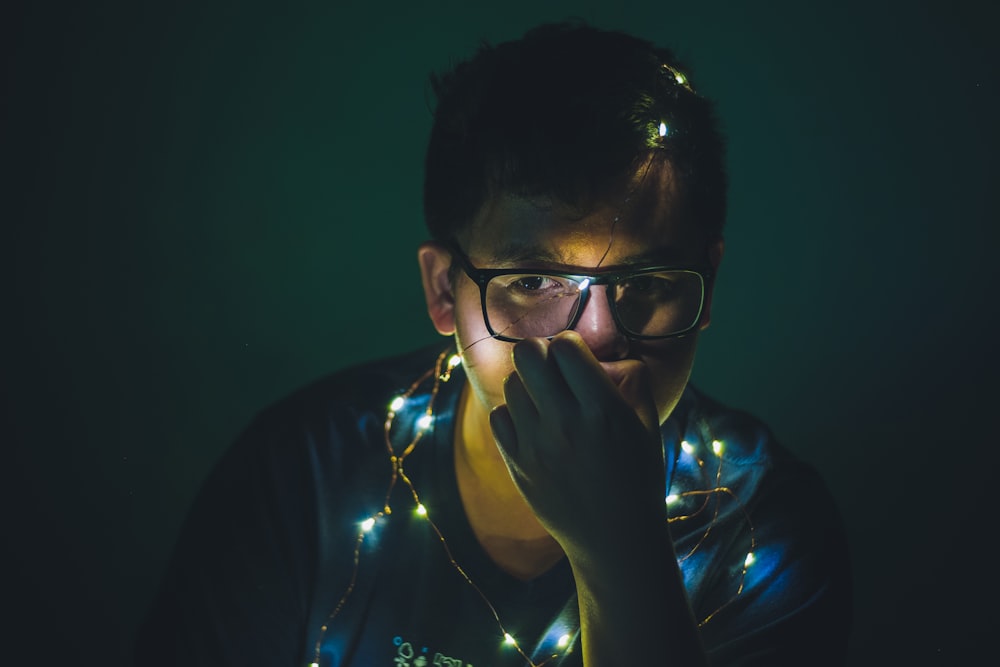 man in blue crew neck shirt wearing black framed eyeglasses