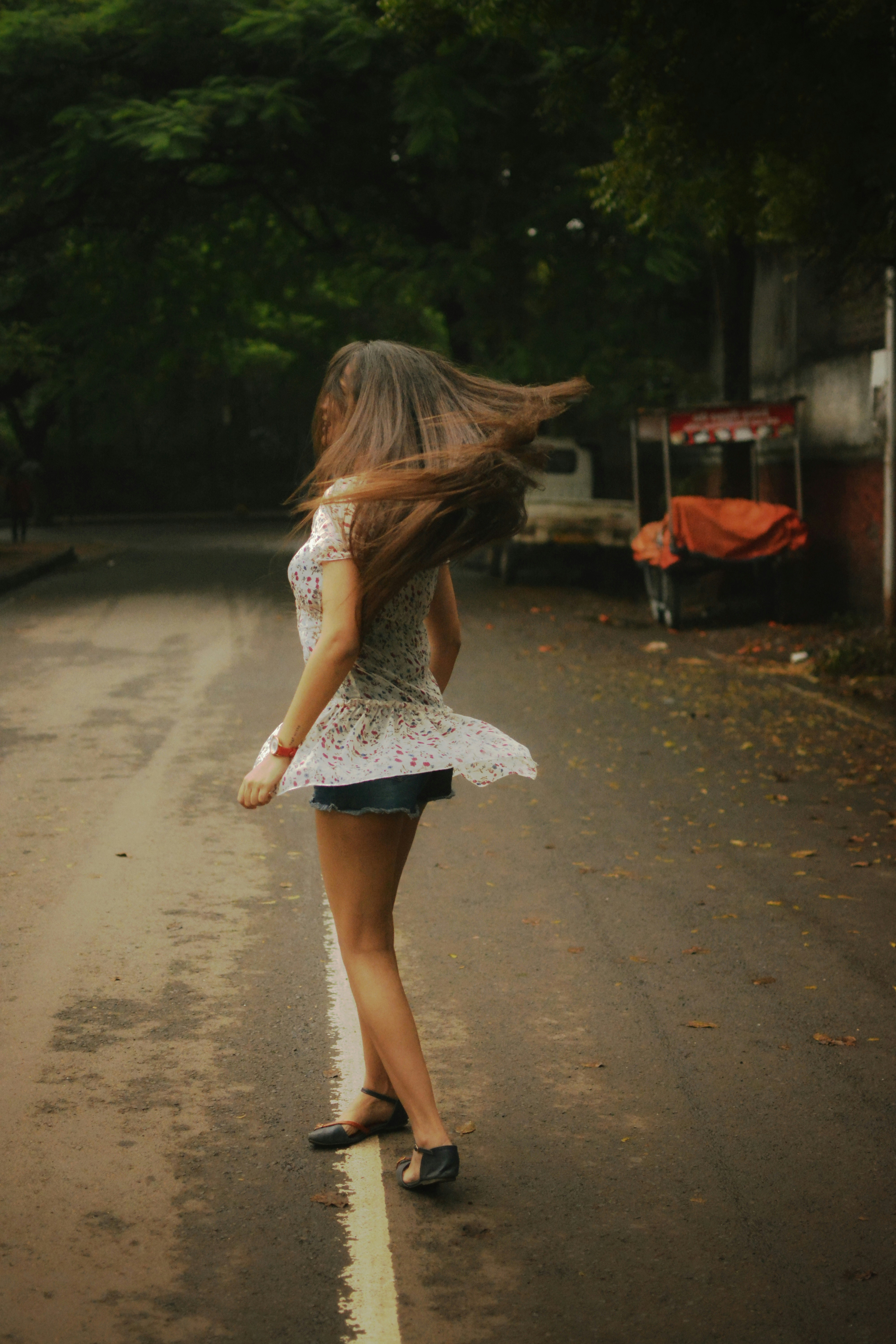 A woman with long hair walking down a street photo – Free Image on Unsplash