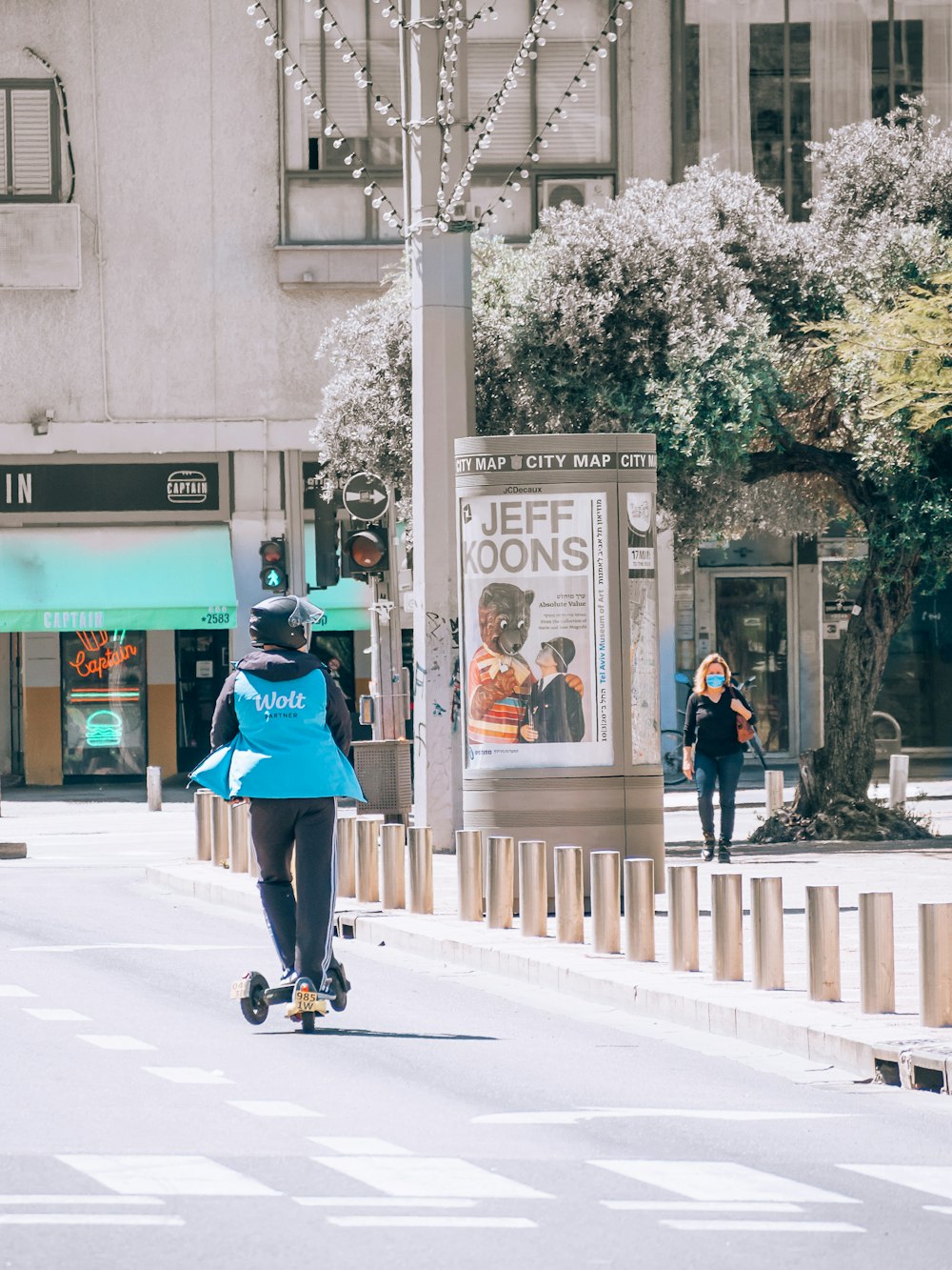 woman in green jacket and black pants riding on black skateboard during daytime