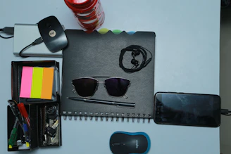 Collection of branded office gadgets including pens, notebooks, and USB drives arranged neatly.