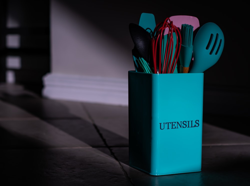 a blue utensil holder with utensils in it