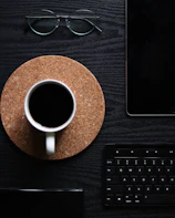 A creative flat lay featuring a laptop, smartphone with Magic Potion Press app, and a cup of coffee.