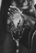 grayscale photo of person wearing beaded bracelet