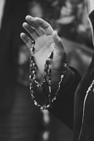 grayscale photo of person wearing beaded bracelet