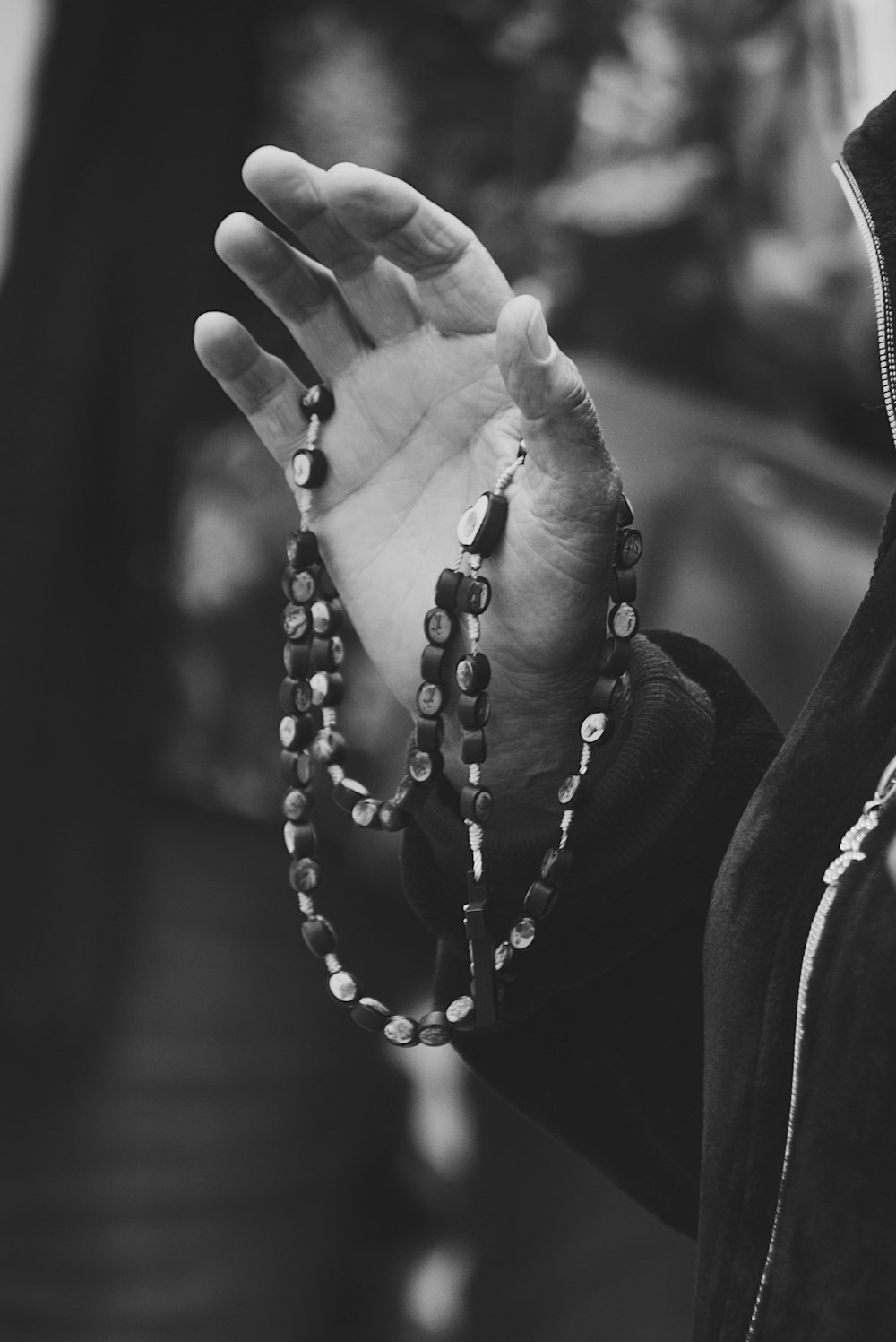 grayscale photo of person wearing beaded bracelet