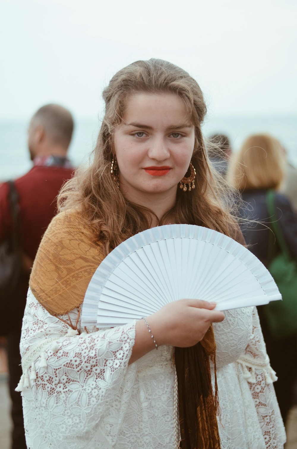 woman in white floral dress holding white hand fan