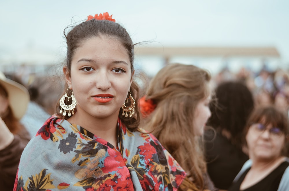 Femme souriante en chemise à fleurs bleue, rouge et blanche