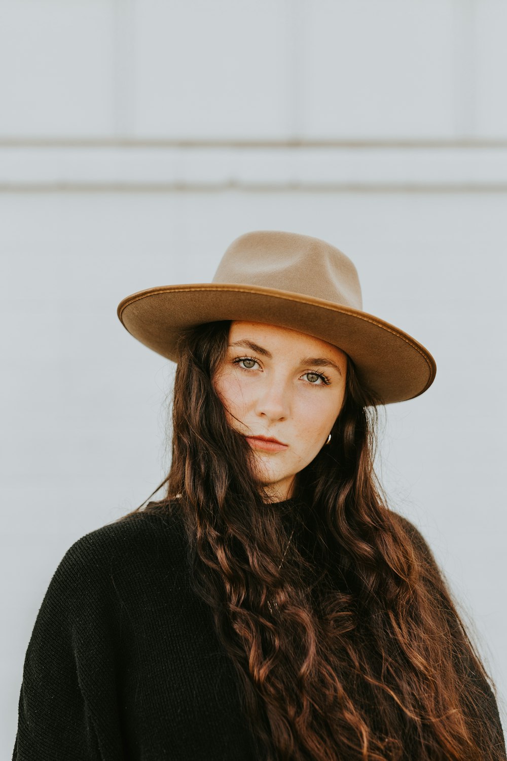 woman in black shirt wearing brown fedora hat