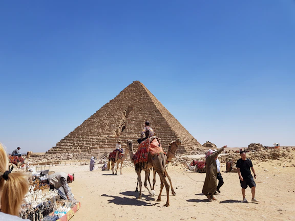A smiling local guide sharing stories beside the Great Pyramid at sunset