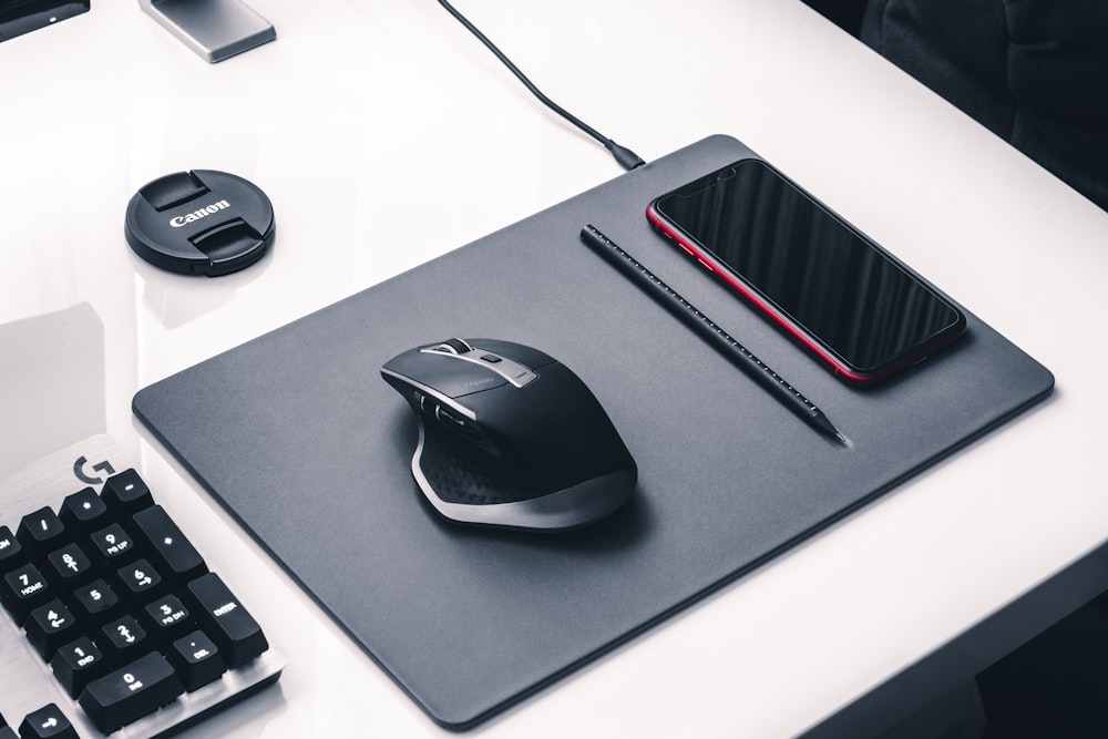 mouse de computador com fio preto e cinza no mouse pad preto