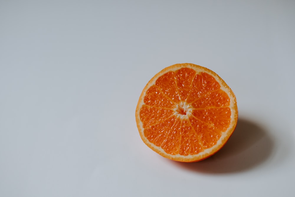fruta laranja fatiada na superfície branca