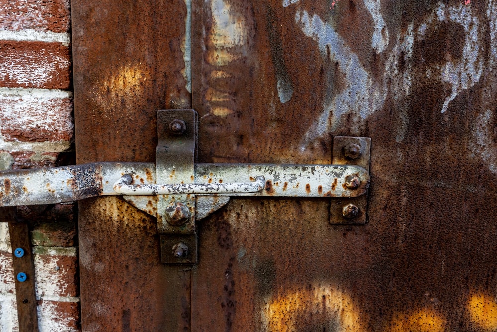a rusted metal door with a latch on it