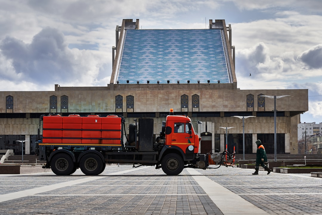 orange and blue truck near brown building during daytime