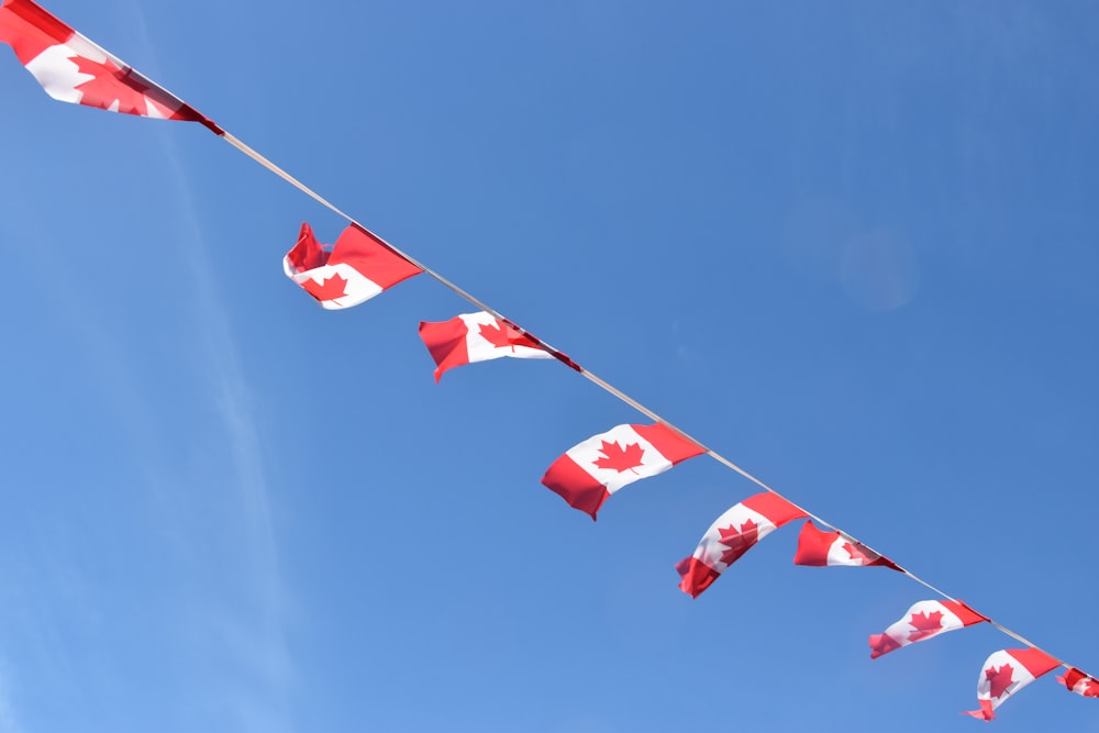 bandeira vermelha e branca no mastro sob o céu azul durante o dia