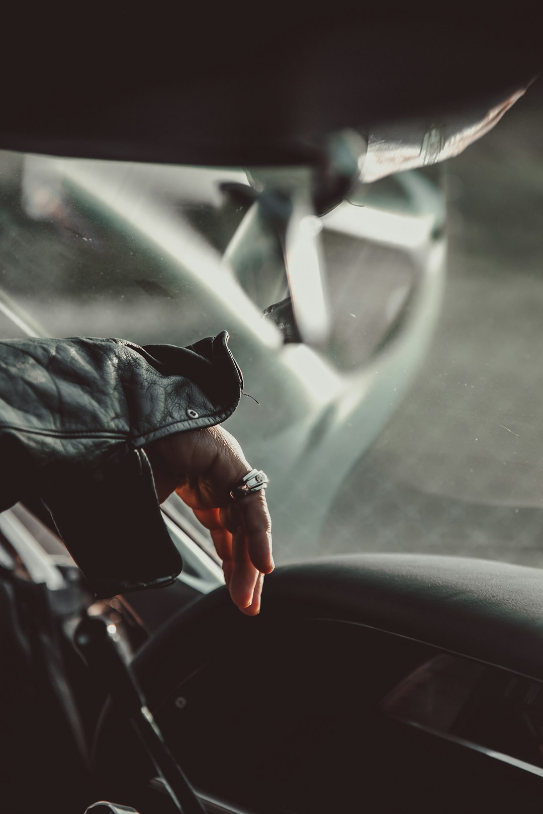 person in black leather jacket driving car