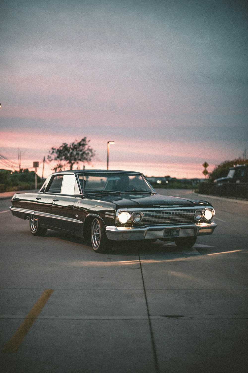 muscle car nera su strada durante il tramonto