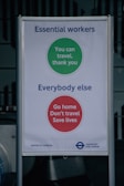 A sign with messages for different groups during the COVID-19 pandemic. The top section, with a green circle, is for essential workers and reads 'You can travel, thank you.' The bottom section, with a red circle, targets everybody else with the message 'Go home, Don't travel, Save lives.' It includes branding for the Mayor of London and Transport for London.