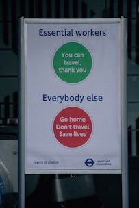 A sign with messages for different groups during the COVID-19 pandemic. The top section, with a green circle, is for essential workers and reads 'You can travel, thank you.' The bottom section, with a red circle, targets everybody else with the message 'Go home, Don't travel, Save lives.' It includes branding for the Mayor of London and Transport for London.
