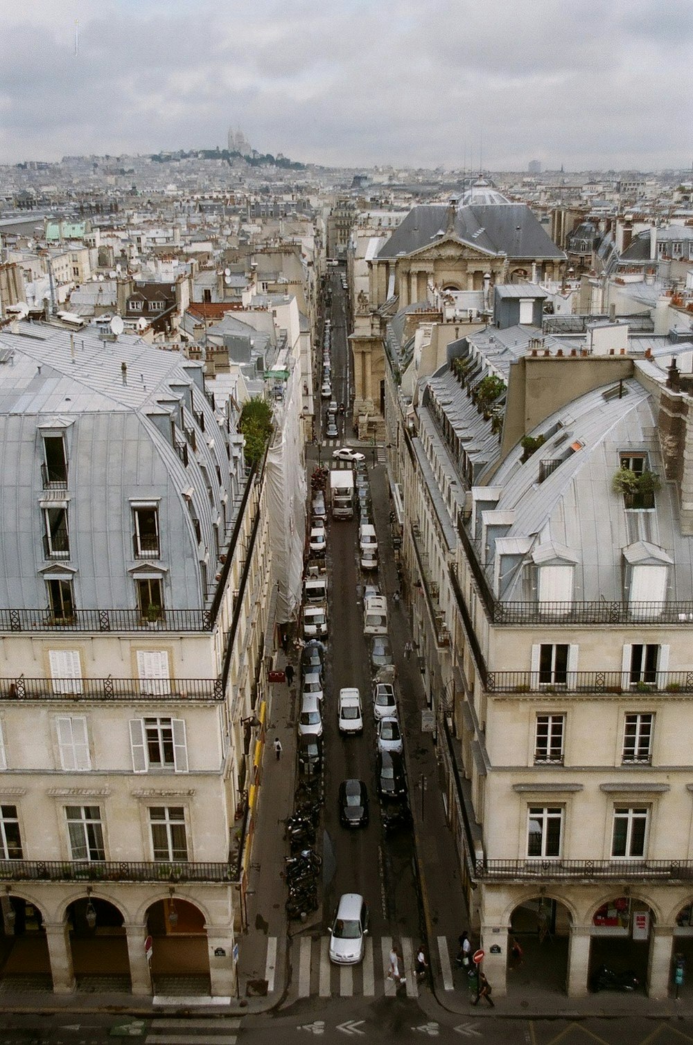 cars on road between buildings during daytime