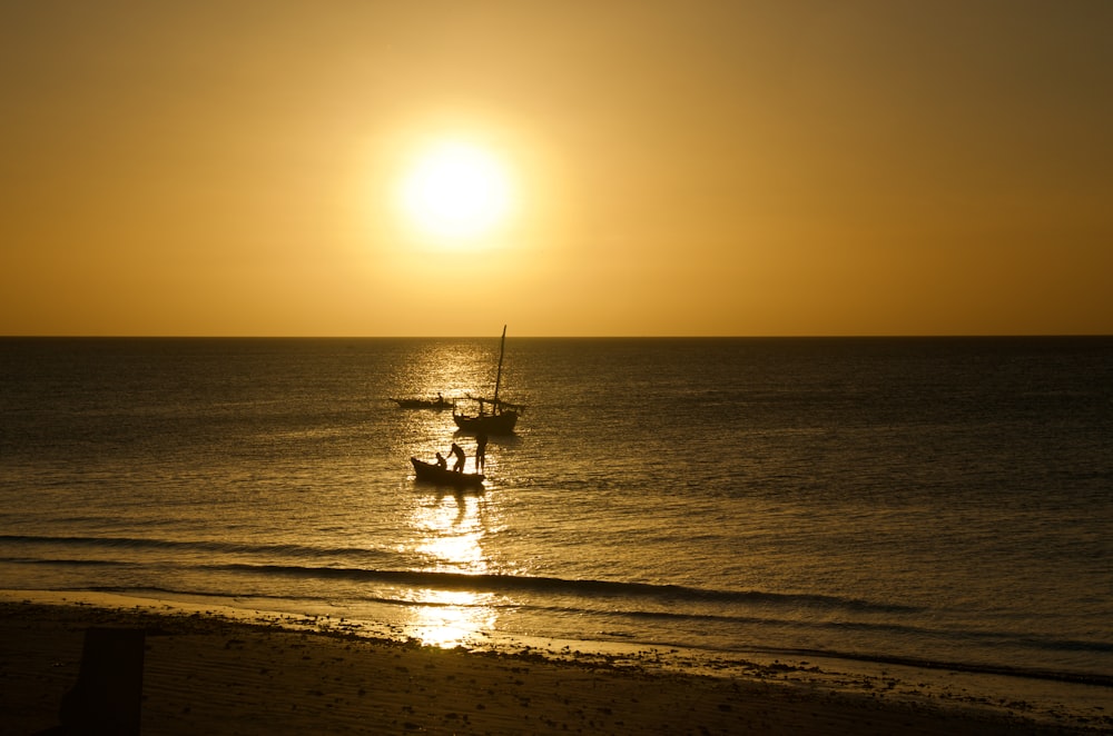 Silhouette der Person, die während des Sonnenuntergangs auf dem Boot fährt