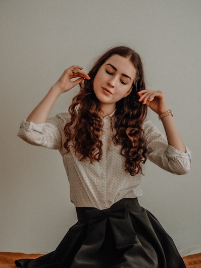 woman in white long sleeve shirt and black skirt