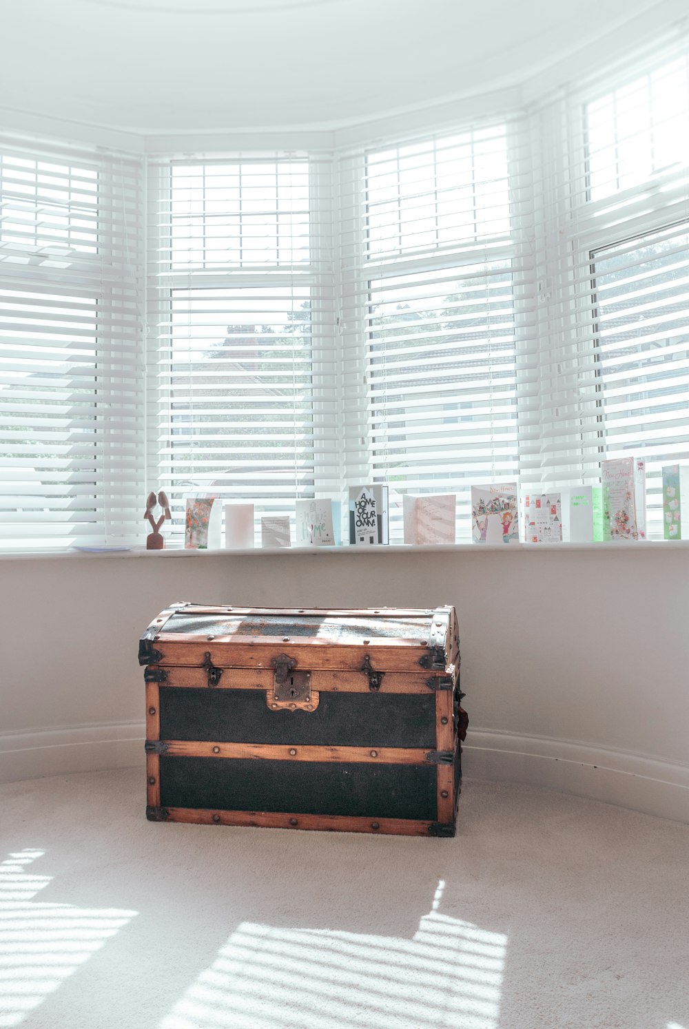 brown wooden chest box near white window blinds