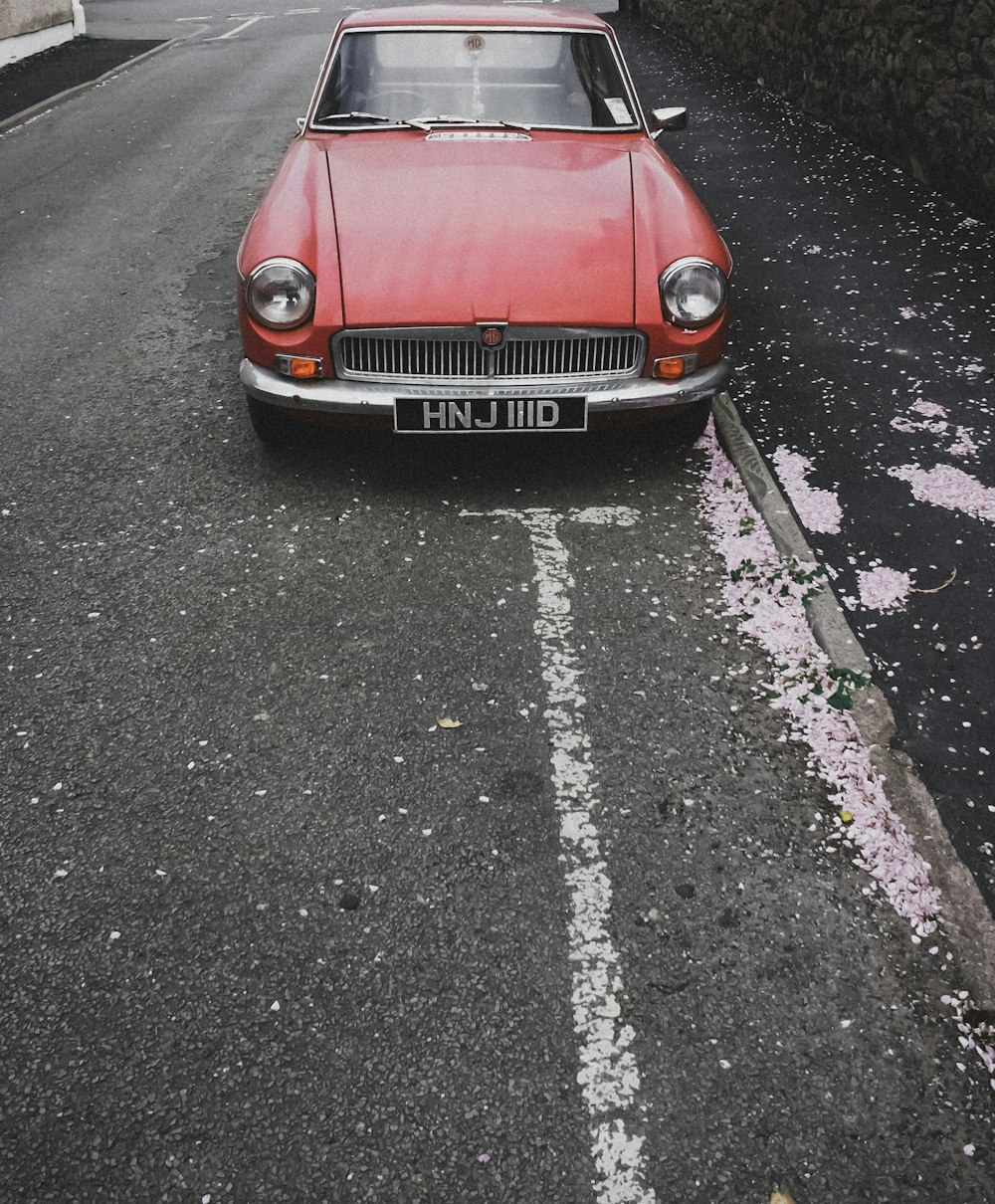 carro vermelho na estrada de asfalto cinza durante o dia
