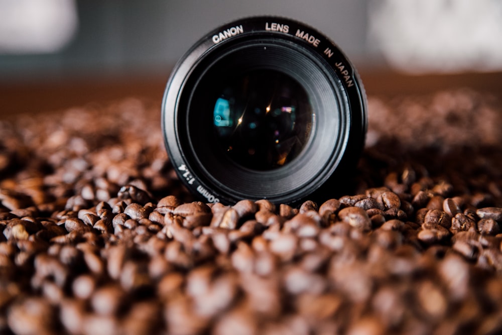black nikon camera lens on brown and black stones