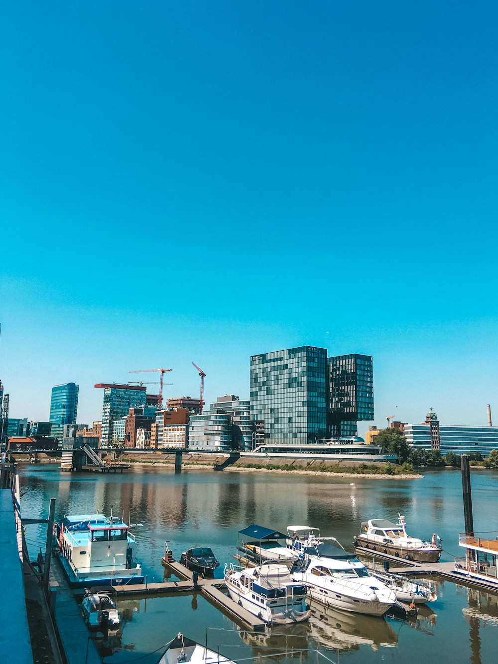 Bote blanco y negro en el cuerpo de agua cerca de los edificios de la ciudad durante el día