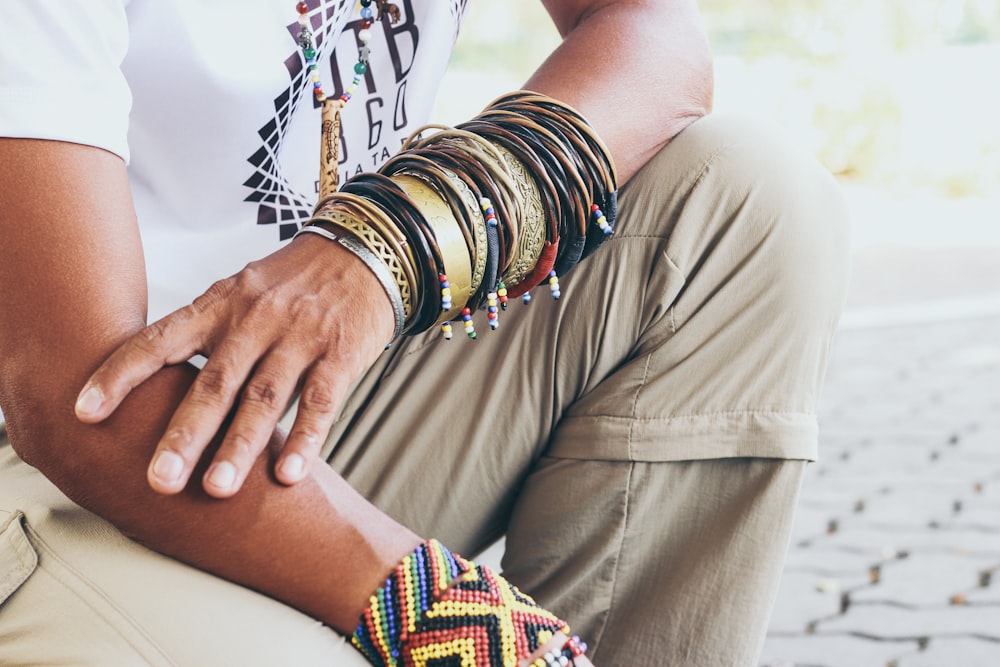 person wearing gold and blue bracelets