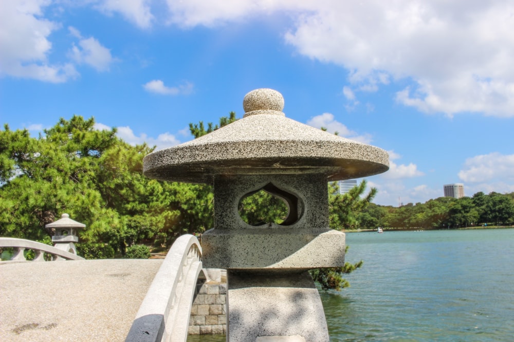 gray concrete bench near body of water during daytime