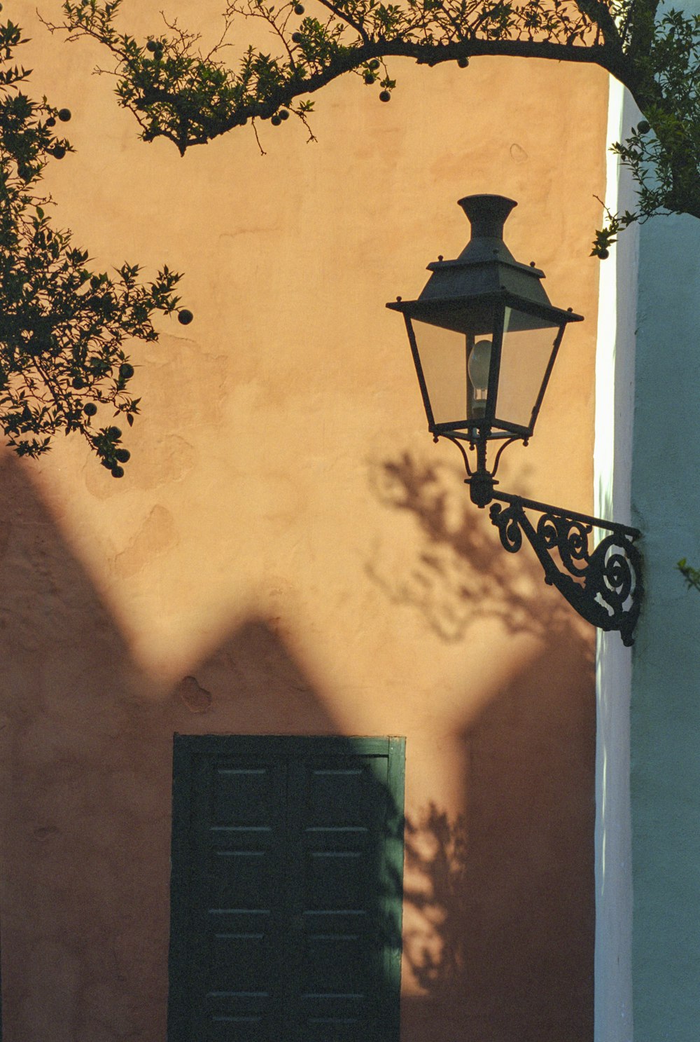 Lámpara de candelabro negro en pared pintada de amarillo