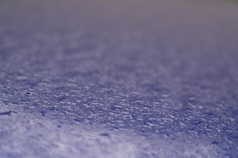 Macro shot of water droplets beading on a treated paper surface.